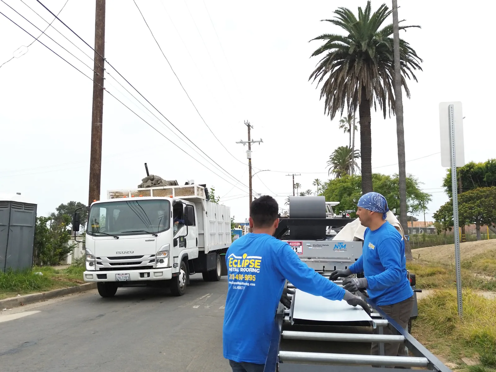 Eclipse Metal Roofing crew feeding a standing seam panel off an on-site roll former