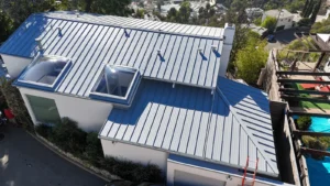Aerial view of a light gray standing seam metal roof with two flat skylights